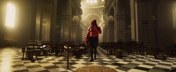 Movie still from “Hellboy” (2019), directed by Neil Marshall – A man in a red shirt is standing in a room; Wide shot, Low angle