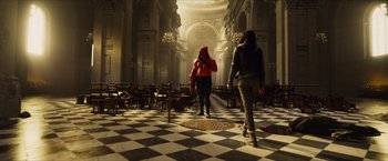 Movie still from “Hellboy” (2019), directed by Neil Marshall – A man in a red jacket standing next to a woman in a black and white checkered floor; Wide shot, High angle