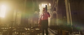 Movie still from “Hellboy” (2019), directed by Neil Marshall – A man with a gas mask holding a gun in a church; Wide shot, Low angle