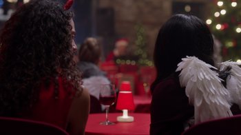 Movie still from “Under the Christmas Tree” (2021), directed by Lisa Rose Snow – Two women are sitting at a table with a glass of wine; Close Up shot, Over the shoulder angle