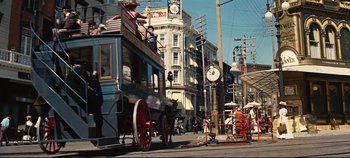 Movie still from “Hello, Dolly!” (1969), directed by Gene Kelly – A horse drawn carriage on a city street; Extreme Wide shot, Low angle