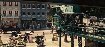 Movie still from “Hello, Dolly!” (1969), directed by Gene Kelly – A group of people sitting around a building; Extreme Wide shot, High angle