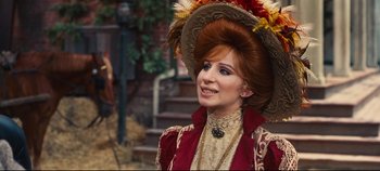 Movie still from “Hello, Dolly!” (1969), directed by Gene Kelly – A woman in a red and gold dress and a brown hat; Close Up shot, Over the shoulder angle