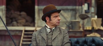 Movie still from “Hello, Dolly!” (1969), directed by Gene Kelly – A man wearing a suit and a hat; Close Up shot, Over the shoulder angle
