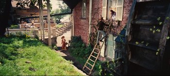 Movie still from “Hello, Dolly!” (1969), directed by Gene Kelly – A man on a ladder on the side of a house; Extreme Wide shot, High angle
