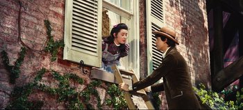 Movie still from “Hello, Dolly!” (1969), directed by Gene Kelly – A man and a woman standing in a window sill; Medium shot, Low angle