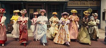Movie still from “Hello, Dolly!” (1969), directed by Gene Kelly – A group of women dressed in period costumes; Wide shot, Low angle