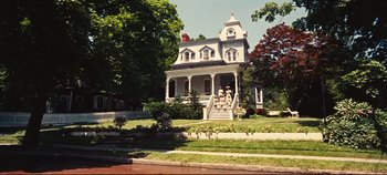 Movie still from “Hello, Dolly!” (1969), directed by Gene Kelly – A large white house with a statue on top of the steps; Extreme Wide shot, Low angle