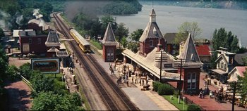 Movie still from “Hello, Dolly!” (1969), directed by Gene Kelly – A train station with people waiting on the tracks; Extreme Wide shot, High angle