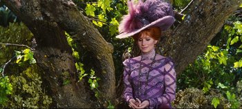 Movie still from “Hello, Dolly!” (1969), directed by Gene Kelly – A woman wearing a purple dress and a purple hat; Medium shot, Low angle