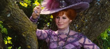 Movie still from “Hello, Dolly!” (1969), directed by Gene Kelly – A woman wearing a purple dress and a purple hat; Close Up shot, Low angle