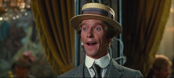 Movie still from “Hello, Dolly!” (1969), directed by Gene Kelly – A person wearing a suit and a straw hat; Close Up shot, Low angle