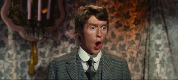 Movie still from “Hello, Dolly!” (1969), directed by Gene Kelly – A man wearing a suit and tie with his mouth wide open; Close Up shot, Low angle