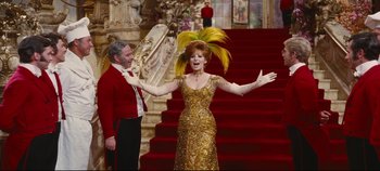 Movie still from “Hello, Dolly!” (1969), directed by Gene Kelly – A man and a woman dressed in formal wear; Wide shot, Low angle