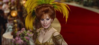 Movie still from “Hello, Dolly!” (1969), directed by Gene Kelly – A woman in a gold dress with feathers on her head; Close Up shot, Over the shoulder angle