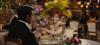 Movie still from “Hello, Dolly!” (1969), directed by Gene Kelly – A woman sitting at a dinner table with a man; Medium shot, Over the shoulder angle