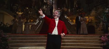 Movie still from “Hello, Dolly!” (1969), directed by Gene Kelly – An older man in a red jacket and a white shirt; Medium shot, Low angle