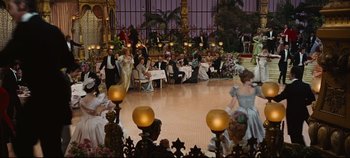 Movie still from “Hello, Dolly!” (1969), directed by Gene Kelly – A group of people sitting and standing around a room; Extreme Wide shot, High angle