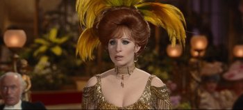 Movie still from “Hello, Dolly!” (1969), directed by Gene Kelly – A person wearing a dress with feathers; Close Up shot, Over the shoulder angle