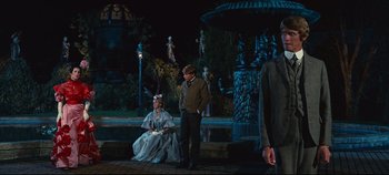 Movie still from “Hello, Dolly!” (1969), directed by Gene Kelly – A man and a woman dressed in period clothing; Wide shot, Over the shoulder angle