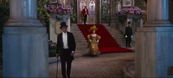 Movie still from “Hello, Dolly!” (1969), directed by Gene Kelly – A man and a woman dressed in formal wear; Wide shot, High angle