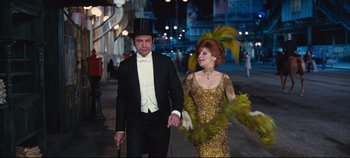 Movie still from “Hello, Dolly!” (1969), directed by Gene Kelly – A man and a woman walking down a street; Medium shot, Low angle