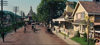 Movie still from “Hello, Dolly!” (1969), directed by Gene Kelly – A street scene with horse and carriage traffic; Extreme Wide shot, High angle