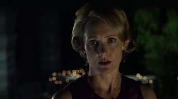 Movie still from “Hellraiser: Revelations” (2011), directed by Víctor Garcia – A woman in a purple dress looking at the camera; Close Up shot, Over the shoulder angle