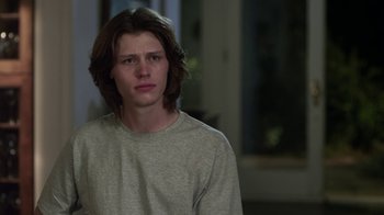 Movie still from “Hellraiser: Revelations” (2011), directed by Víctor Garcia – A man with long brown hair wearing a gray shirt; Close Up shot, Over the shoulder angle