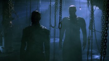 Movie still from “Hellraiser: Revelations” (2011), directed by Víctor Garcia – Two men standing next to each other in a dark room; Medium shot, Low angle