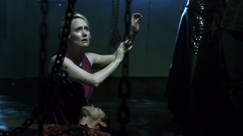 Movie still from “Hellraiser: Revelations” (2011), directed by Víctor Garcia – A woman sitting on the ground next to a man in chains; Medium shot, Over the shoulder angle