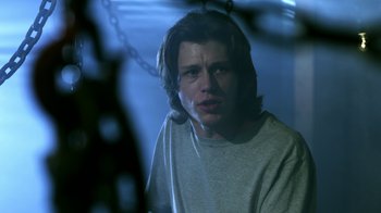 Movie still from “Hellraiser: Revelations” (2011), directed by Víctor Garcia – A man with long hair is sitting in a room; Close Up shot, Low angle