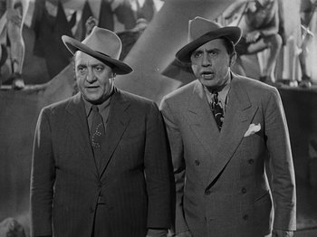 Movie still from “Hellzapoppin'” (1941), directed by H.C. Potter – A couple of men standing next to each other wearing hats; Medium shot, Low angle