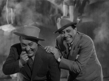 Movie still from “Hellzapoppin'” (1941), directed by H.C. Potter – A couple of men wearing hats and laughing; Medium shot, High angle