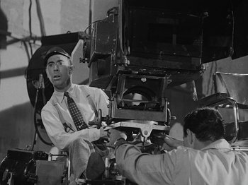 Movie still from “Hellzapoppin'” (1941), directed by H.C. Potter – Two men working together on a film set; Medium shot, Low angle