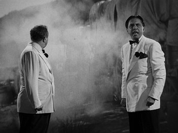 Movie still from “Hellzapoppin'” (1941), directed by H.C. Potter – Two men in white suits standing next to each other in front of smoke; Medium shot, Low angle