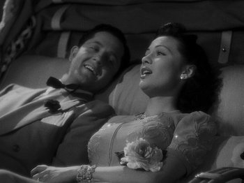 Movie still from “Hellzapoppin'” (1941), directed by H.C. Potter – A man and a woman sitting next to each other on a couch; Medium shot, High angle