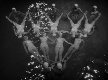 Movie still from “Hellzapoppin'” (1941), directed by H.C. Potter – A group of women in bathing suits are swimming in the water; Extreme Wide shot, Overhead angle