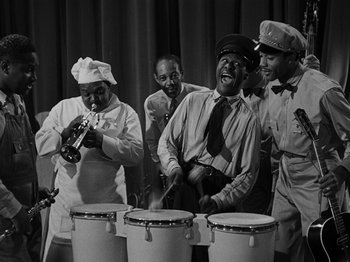 Movie still from “Hellzapoppin'” (1941), directed by H.C. Potter – A black and white photo of a group of men playing drums; Medium shot, High angle