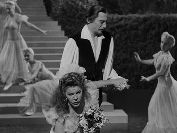 Movie still from “Hellzapoppin'” (1941), directed by H.C. Potter – A man and a woman are standing in front of a staircase; Medium shot, Over the shoulder angle