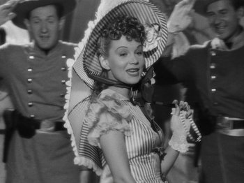 Movie still from “Hellzapoppin'” (1941), directed by H.C. Potter – An old photo of a woman in a dress and a hat; Medium shot, Low angle