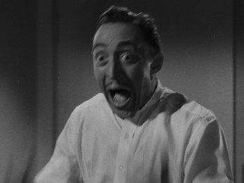Movie still from “Hellzapoppin'” (1941), directed by H.C. Potter – A man in a white dress shirt is making a funny face; Close Up shot, Low angle