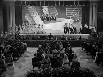 Movie still from “Hellzapoppin'” (1941), directed by H.C. Potter – An audience is sitting in front of a stage; Extreme Wide shot, High angle