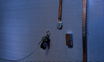 Movie still from “Help!” (1965), directed by Richard Lester – A blue wall with a key chain and a camera; Extreme Close Up shot, Overhead angle