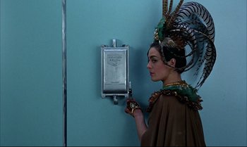 Movie still from “Help!” (1965), directed by Richard Lester – A woman in a costume standing in front of an electrical box; Close Up shot, Low angle