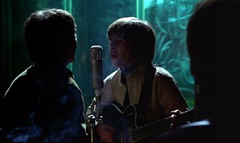Movie still from “Help!” (1965), directed by Richard Lester – Two young men are singing and playing a guitar; Close Up shot, Over the shoulder angle