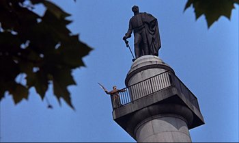 Movie still from “Help!” (1965), directed by Richard Lester – A man standing on top of a tall building; Extreme Wide shot, Low angle