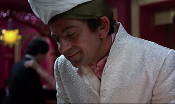 Movie still from “Help!” (1965), directed by Richard Lester – A man wearing a white suit and a hat; Close Up shot, High angle