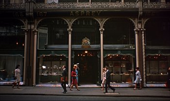Movie still from “Help!” (1965), directed by Richard Lester – A group of people walking down a street; Extreme Wide shot, Low angle