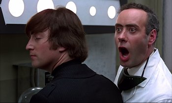Movie still from “Help!” (1965), directed by Richard Lester – Two men in black shirts and white ties looking surprised; Close Up shot, Low angle